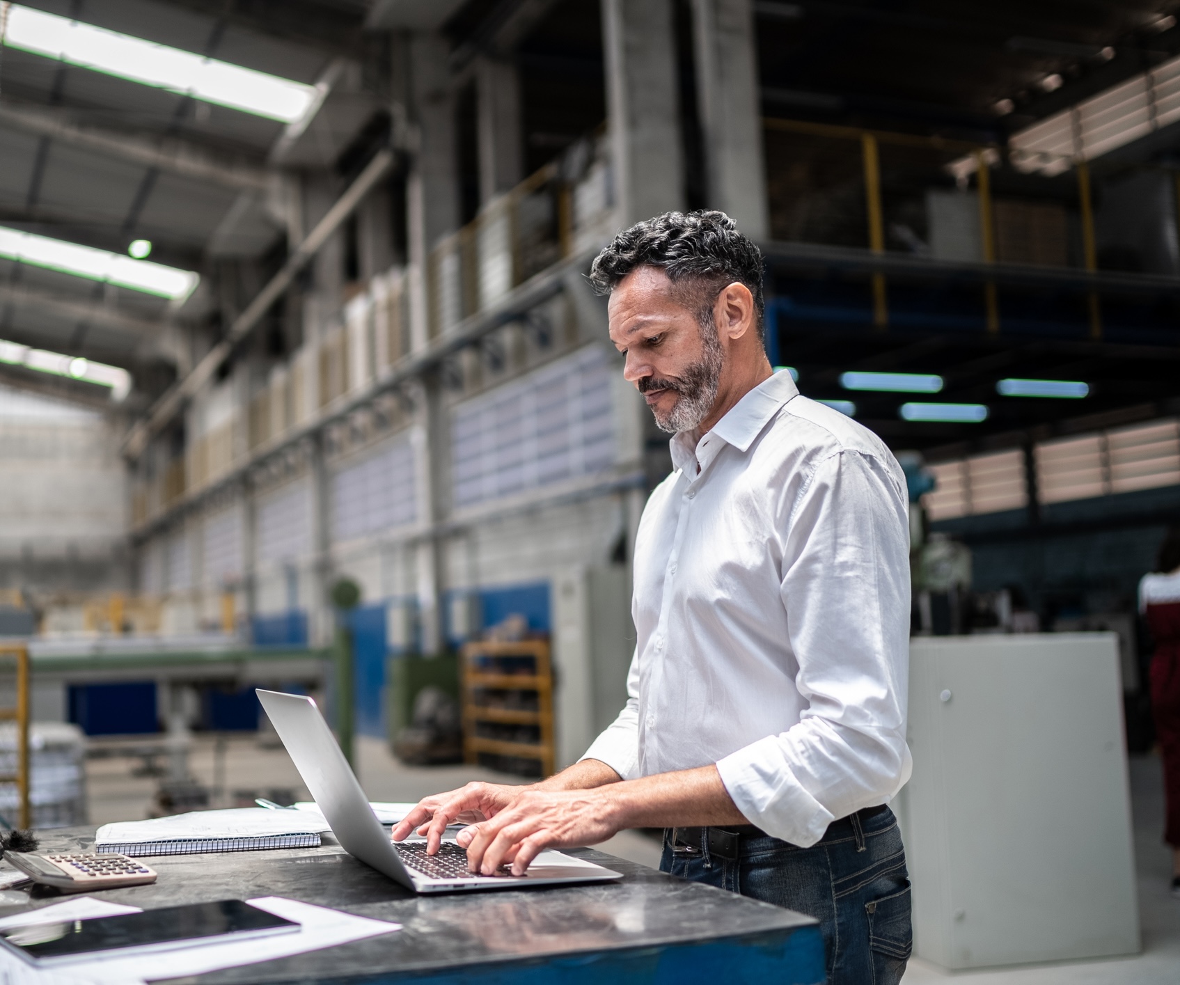 Homme d'affaires d'âge mûr utilisant un ordinateur portable dans une usine